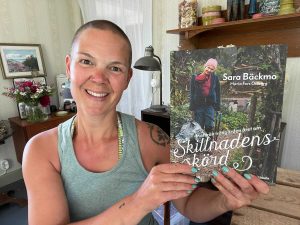 Sara håller sin bok Skillnadens Skörd